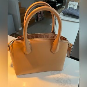 A new day tan satchel with additional long strap.
